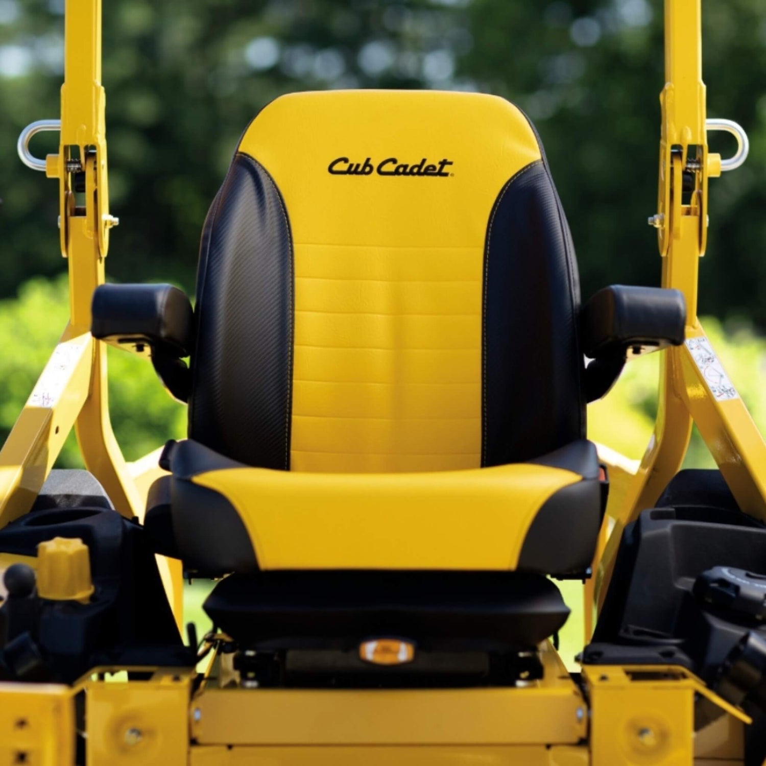 Yellow and black seat of a Cub Cadet lawn mower with a blurred green background.
