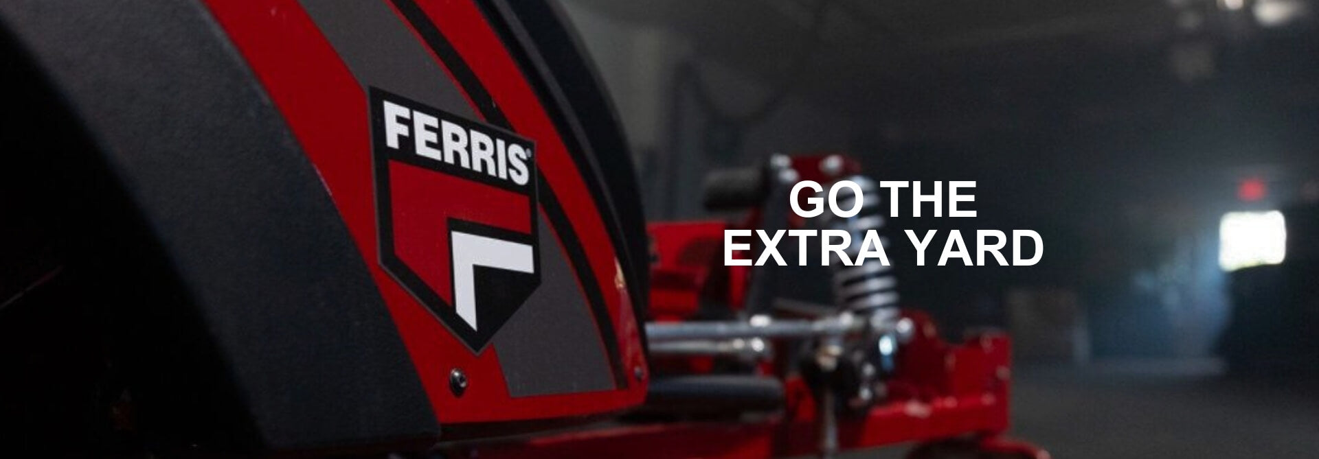 Red lawn mower with Ferris logo and 'Go the Extra Yard' text in a dark setting.