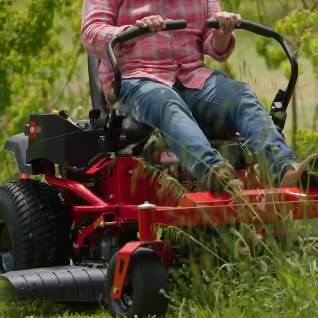Man holding lap bars steering the Rover RZ zero turn ride on mower.