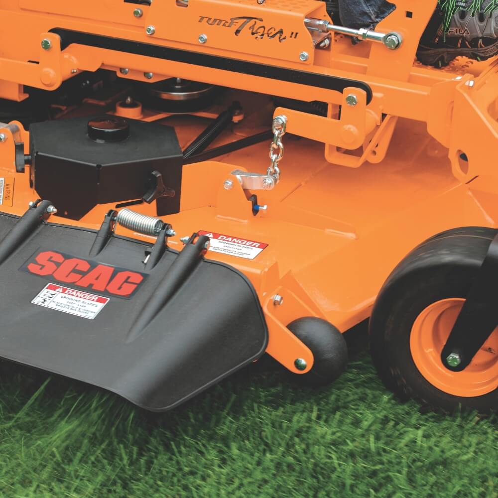 Close-up of an orange SCAC lawn mower on grass
