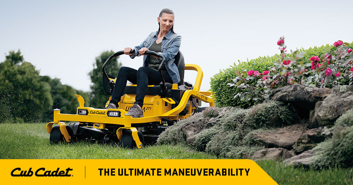 Online banner showing a woman carefully mowing her yellow ride on mower around a rocky garden bed with brand logo and message.